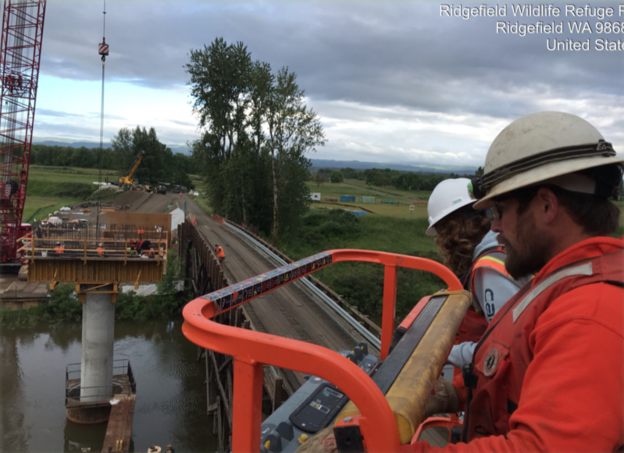Representatives from FHWA and Ciccanti, Inc. use a lift to inspect rebar work on the pier caps.