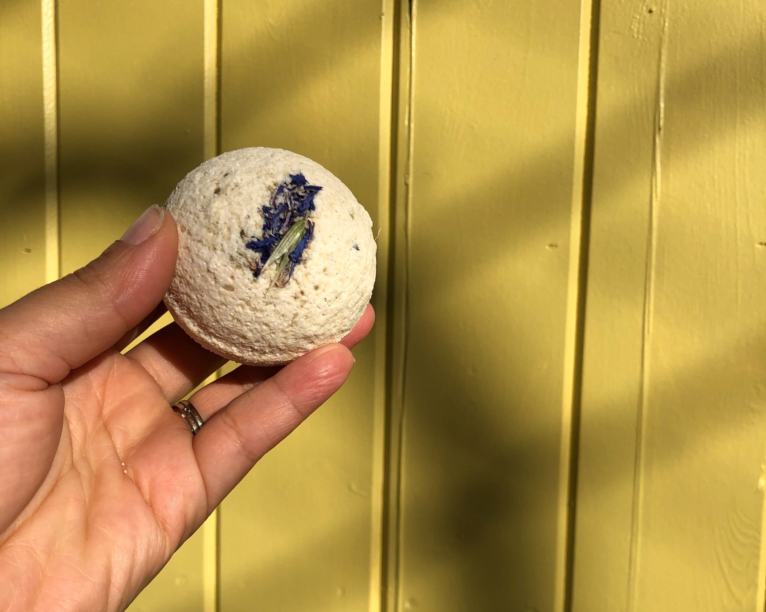 hand holding an ease orb on a yellow background