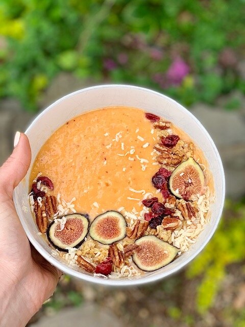 The Carrot Cake: 1/4 cup frozen pineapple, 1/2 frozen mango, 1 banana, 1 apple, 1/4 cup frozen coconut, 1 carrot, 1” fresh turmeric (or sub 1 tsp powder), 1” fresh ginger (or sub 1 tsp powder), 1/2 cup oat milk, and topped with dried cranberries, fresh figs, pecan praline granola from Trader Joe’s, shredded coconut, and raw pecans.