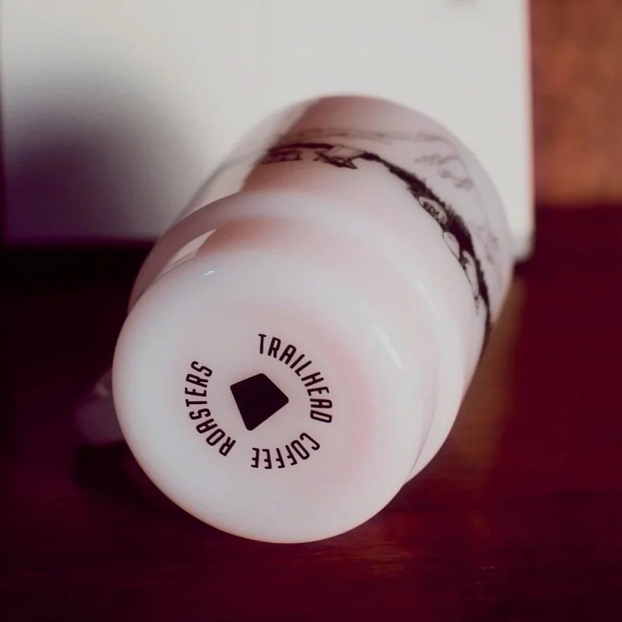 Bottom of our Milk Glass mug in Pink showing the Trailhead logo