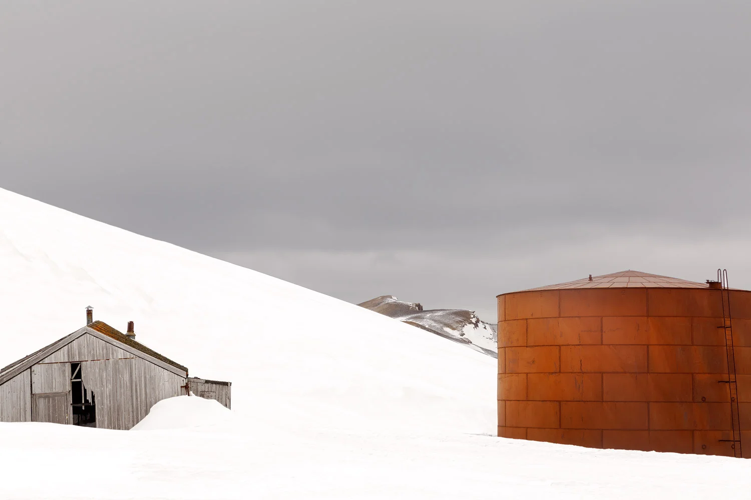old-hut-and-rusted-metal-tank-on-ice-at-abandoned-whaling-station-antarctica.jpg