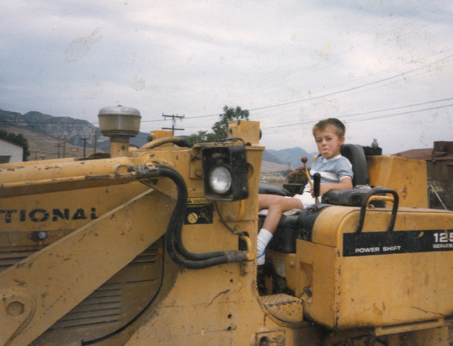 9. Chris sitting on backhoe Castaic Apt - sticking his tongue out.jpg