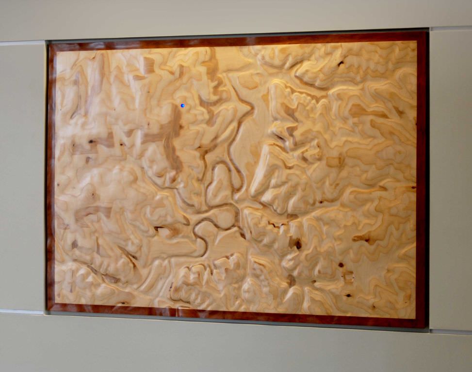  Common Ground: 6’ x 4’ 6” x 2” Baltic birch plywood, cherry wood trim, oil paints, conversion varnish, pulsing led light :: 2009.  The location of the Community Center is marked on the map by the slowly pulsing blue light, and this acts as an orient