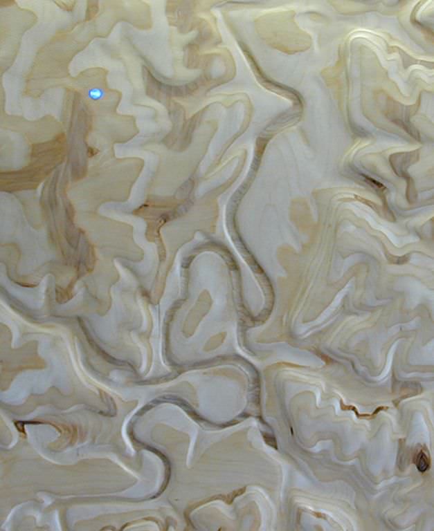  Common Ground: detail prior to varnishing :: 2009.  A close examination of the surface reveals that the Blue River valley has been painted in by hand to look almost exactly like the pattern generated by carving through the layers of plywood. It is h