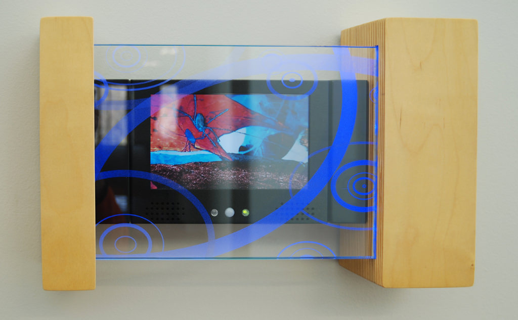  Video Explorers: 1’ 4” x 10” x 3” Baltic birch ply, etched tempered glass, led edge light, solid state media player :: 2009.  Each player contains footage that was composed specifically for its intended target audience. One sequence for the younger 
