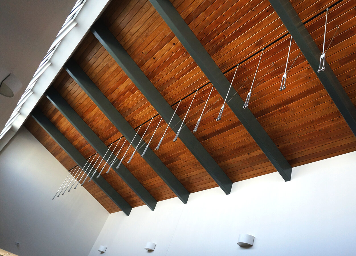                   Coffee Creek Ripple Effect, Water Resource Recovery Facility, Edmond, OK :: 2018.    Ceiling mounts seen from below. Each support shaft is slotted into a continuous channel installed in the ceiling by the General Contractor. This pe