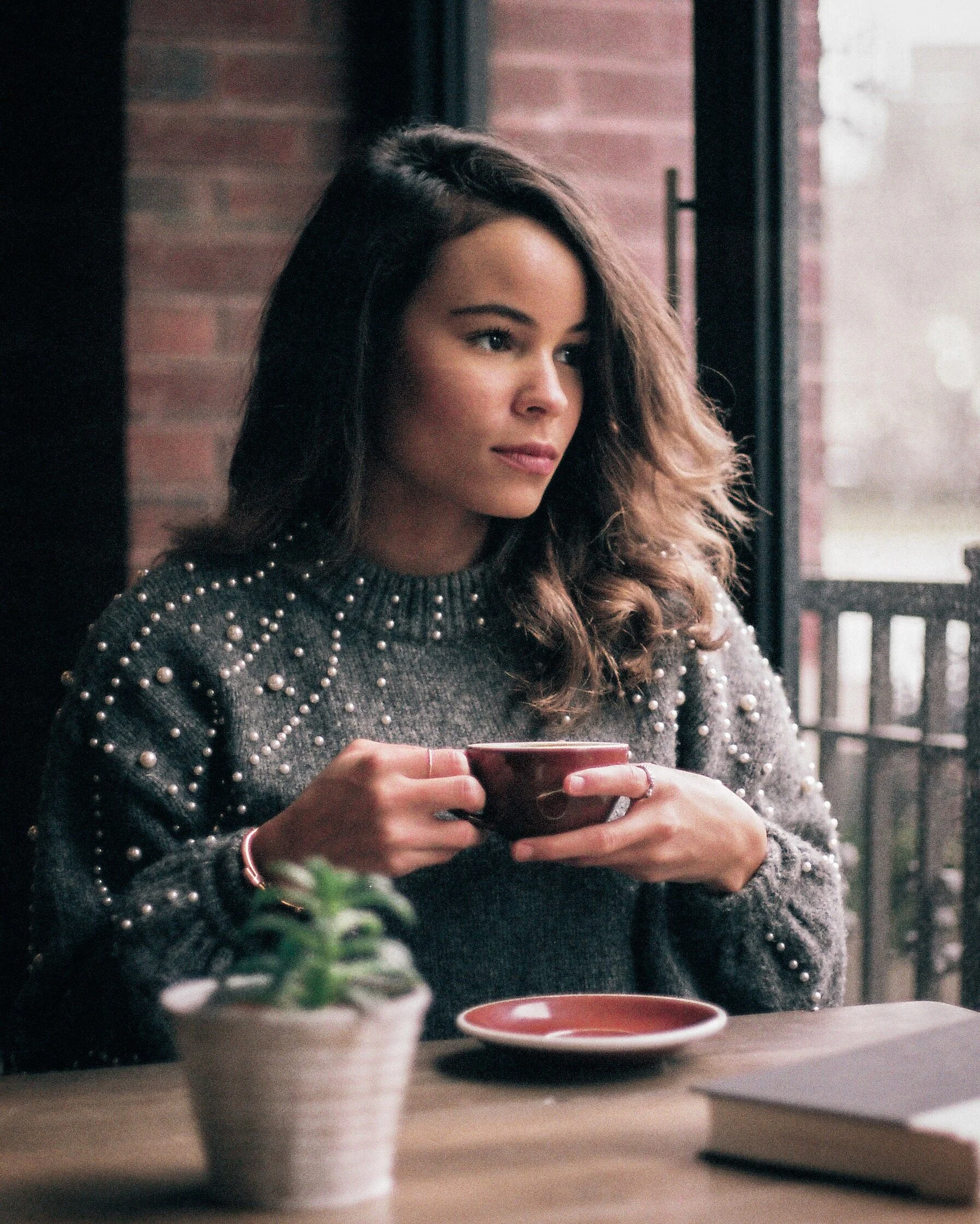 Portrait of Woman in Cafe with Coffee Cup and Plant
