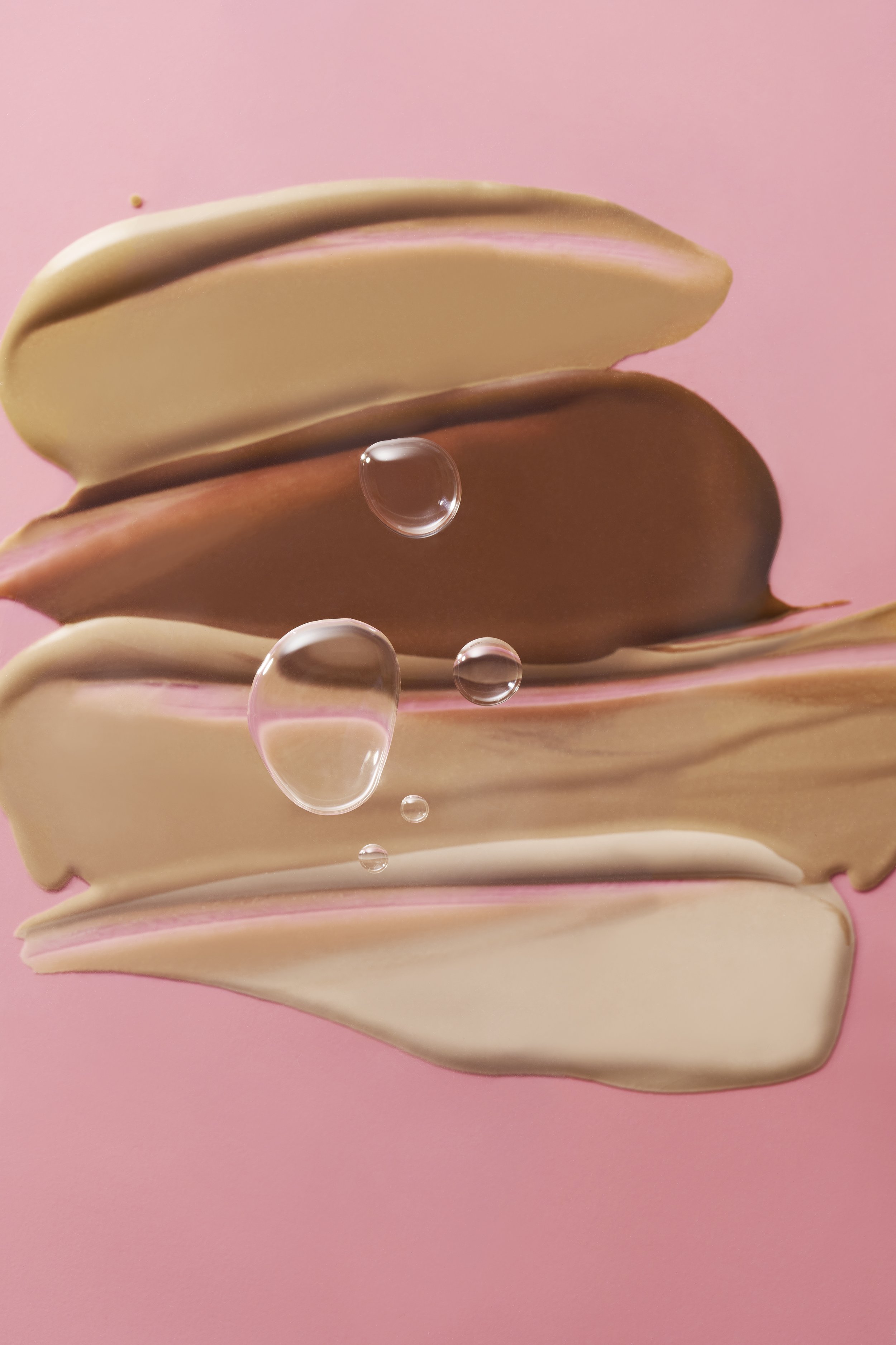 Close-up of white and brown chocolate bars with water droplets on a pink background.