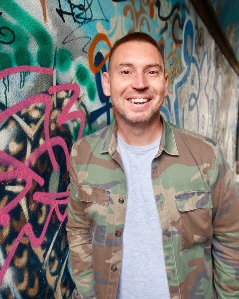 Mark in front of graffiti wall.jpeg