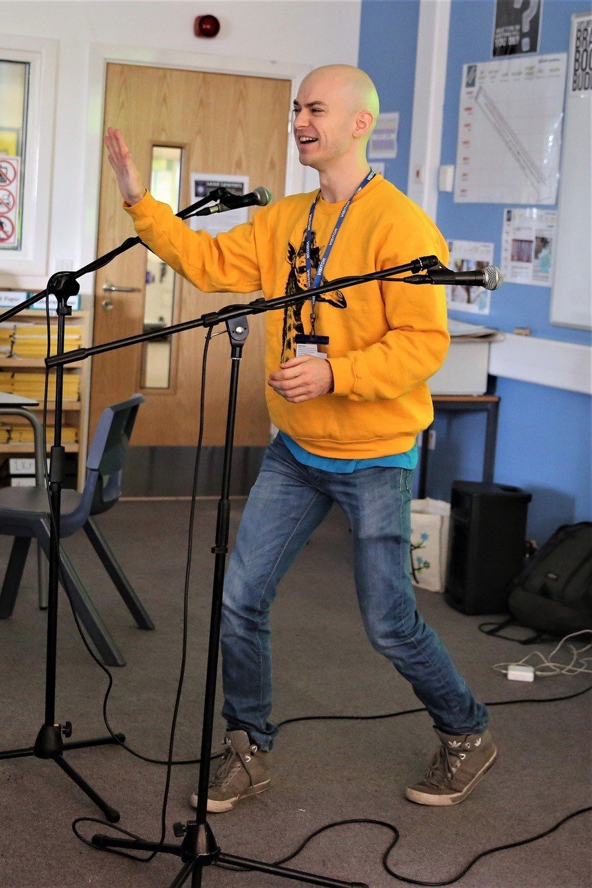 Andy performing in yellow jumper.jpeg