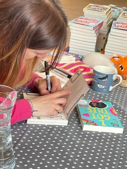 Chrissie signing books.jpg