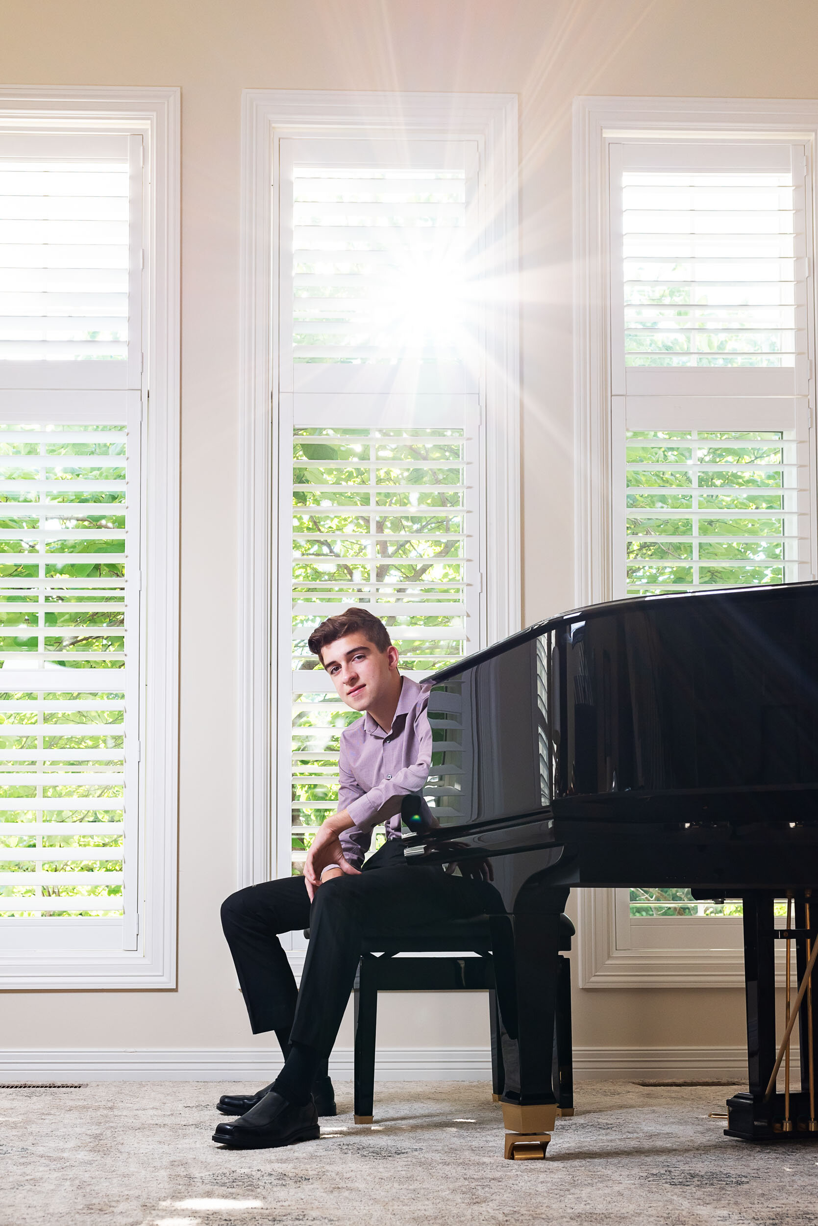 senior-guy-at-home-grand-piano-sun-flare-throgh-window-Jill-Carson-Photography.jpg