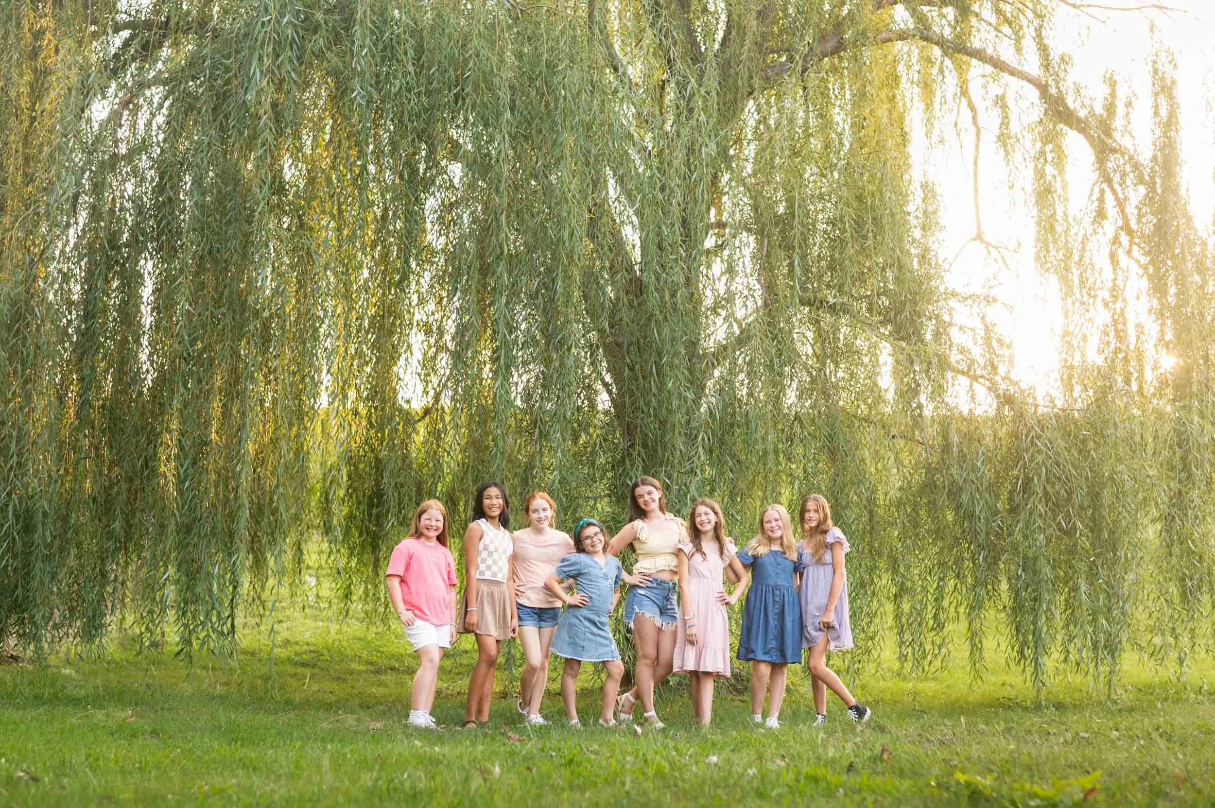 group-tween-girls-standing-beneath-large-willow-tree-camp-cherished-omaha.jpg