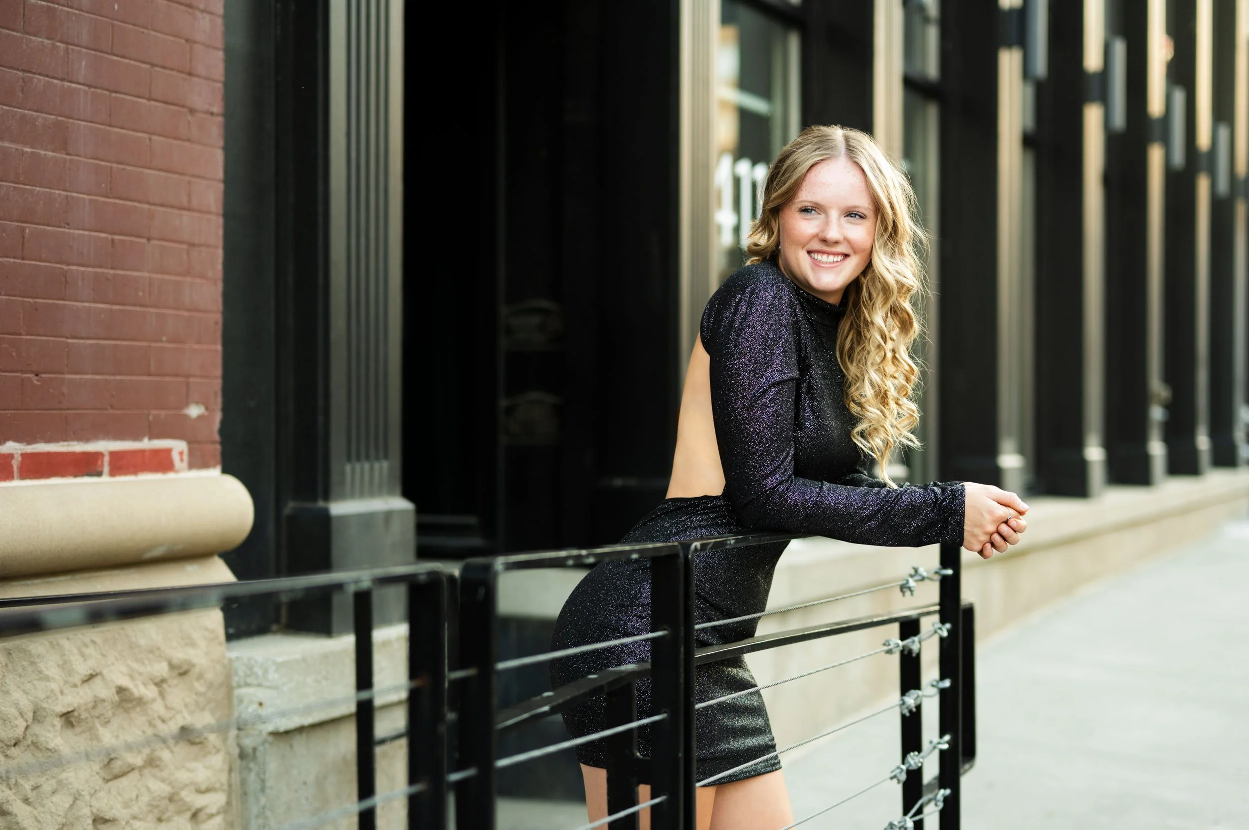 senior-girl-leaning-rail-black-sparkle-dress.jpg