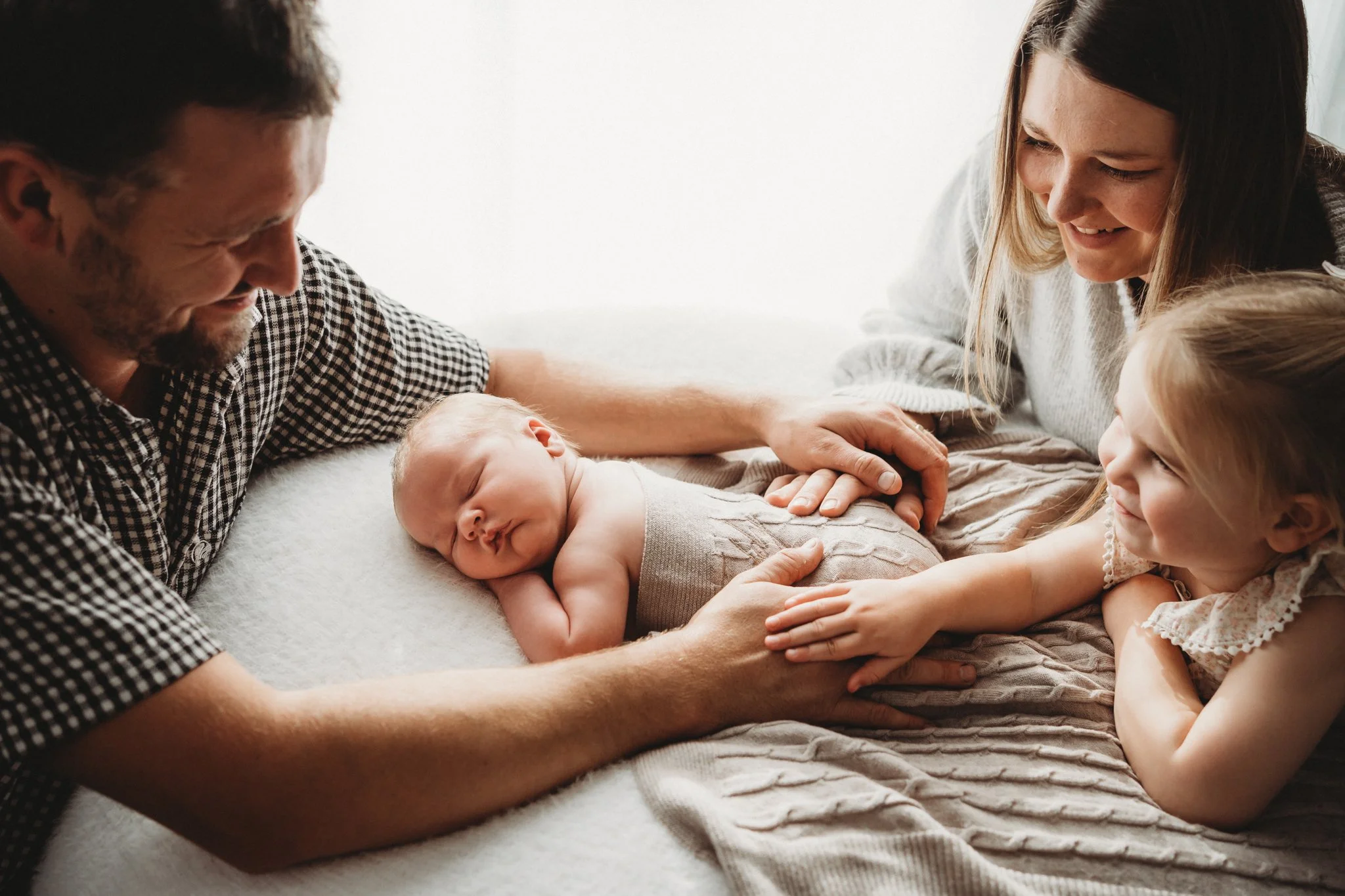 Family all around newborn and admiring the new addition