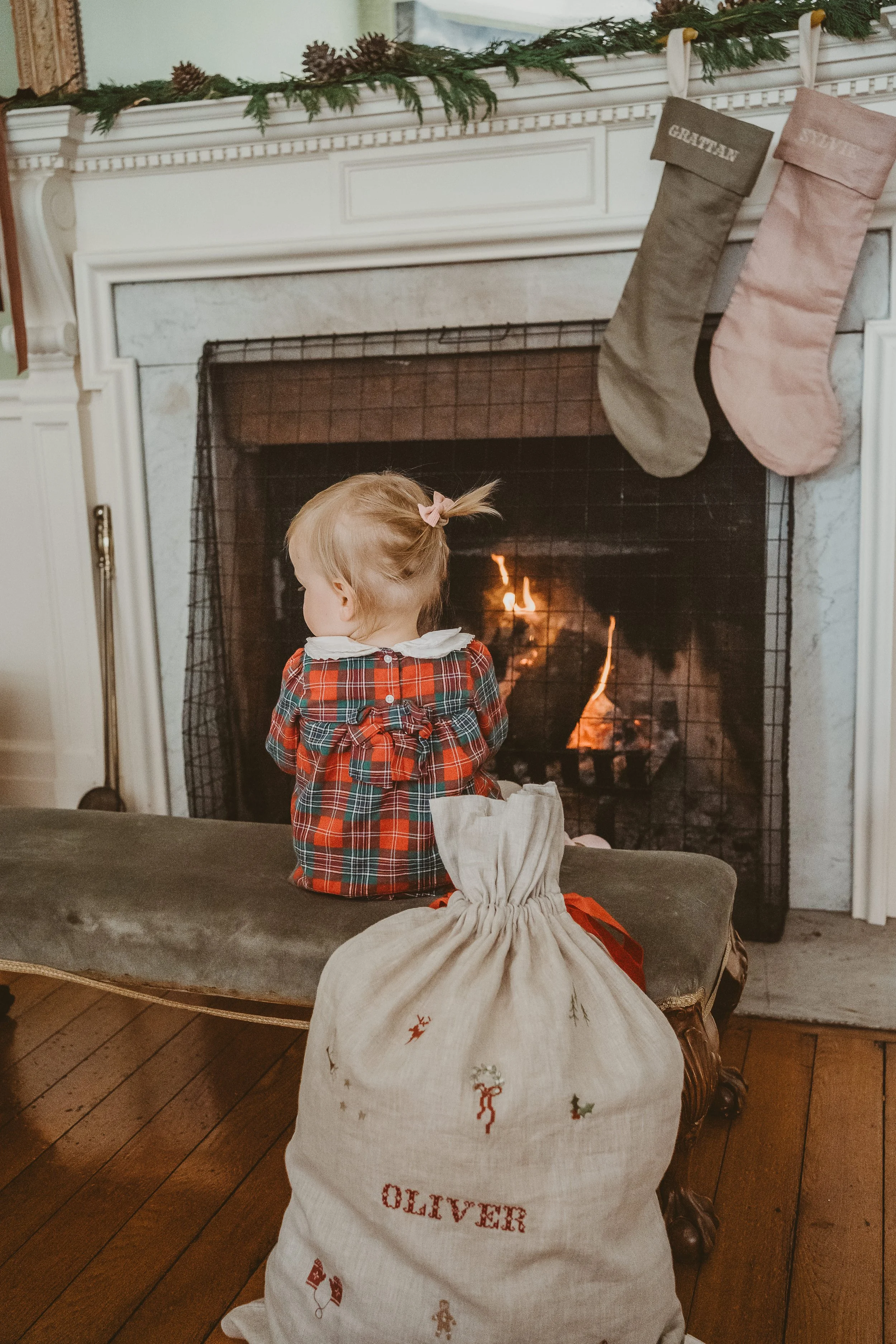 Behind the scenes- child sitting by the fire with Christmas stockings