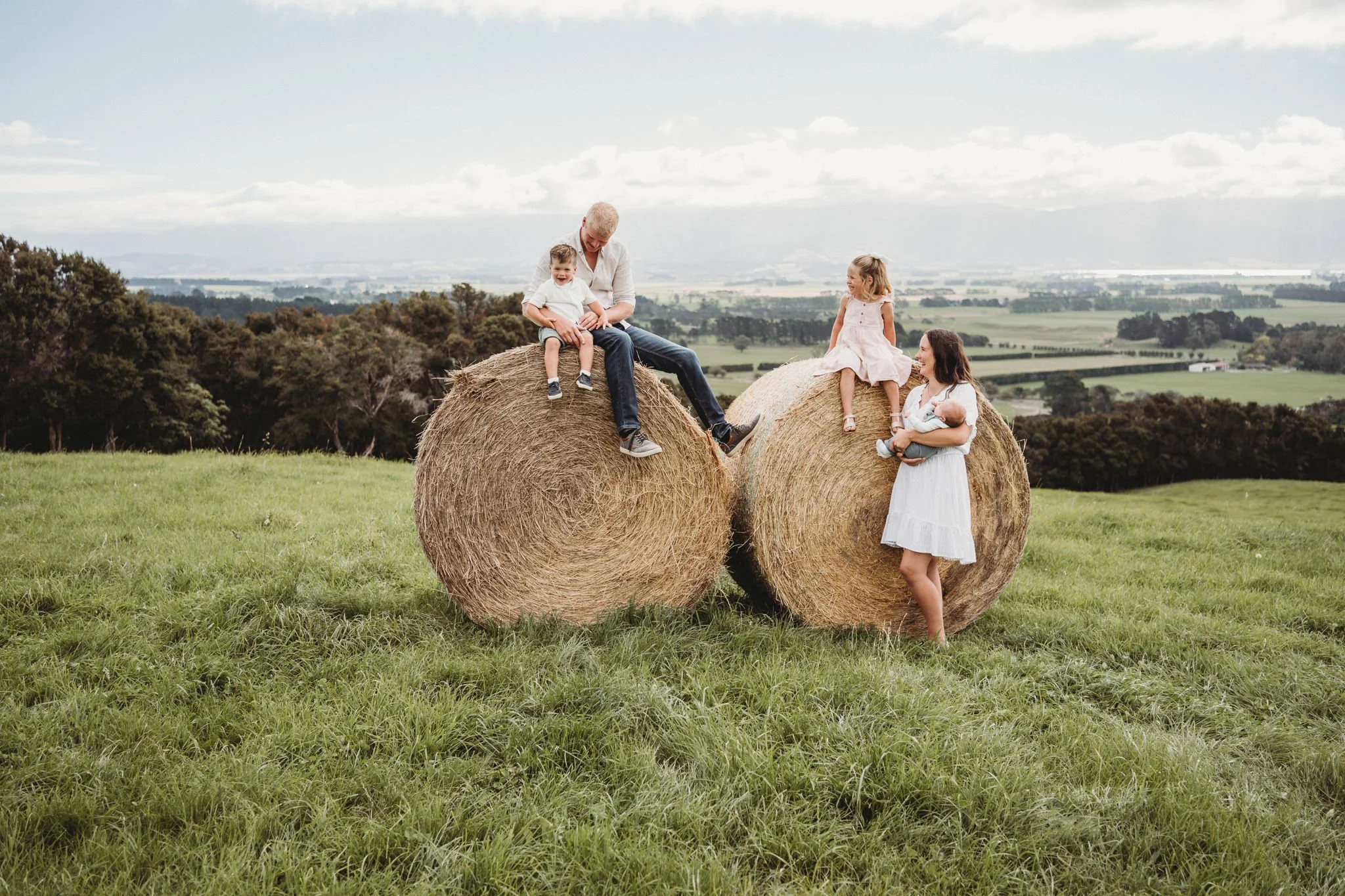 South Wairarapa dairy farming family sitting on hay bales together