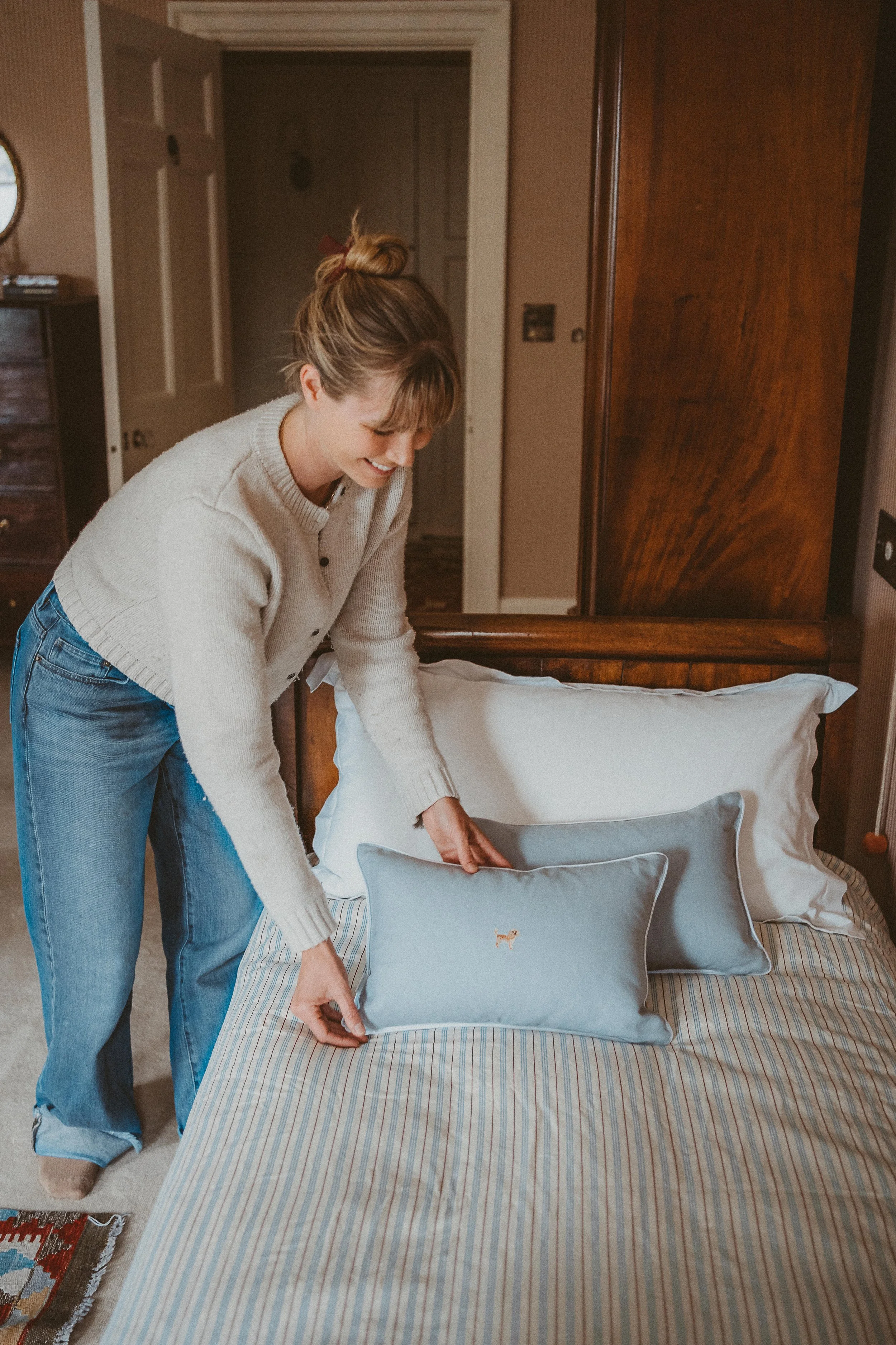 Casual image of Wairarapa business owner adjusting her products on display bed.