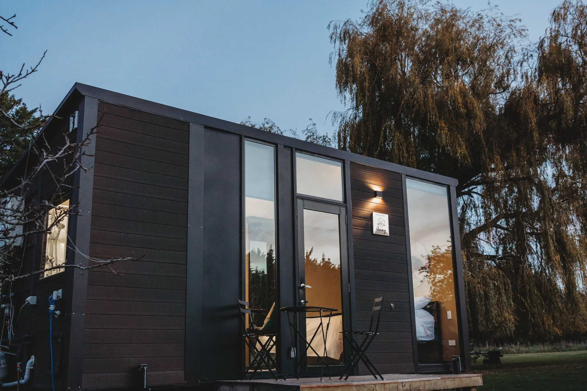 Golden glow of lights shining from Masterton holiday tiny house