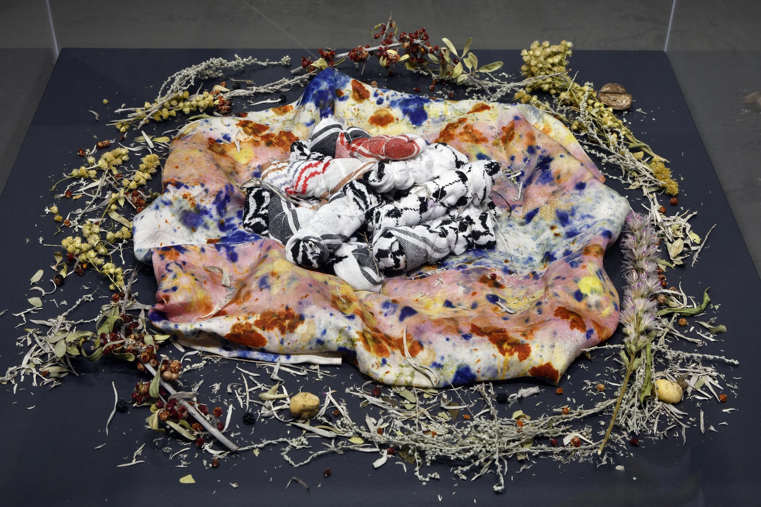  Melanie Monique Rose,  Tiny Bundles of Love , 2025, keffiyeh cloth wrapped in sage, string. 
