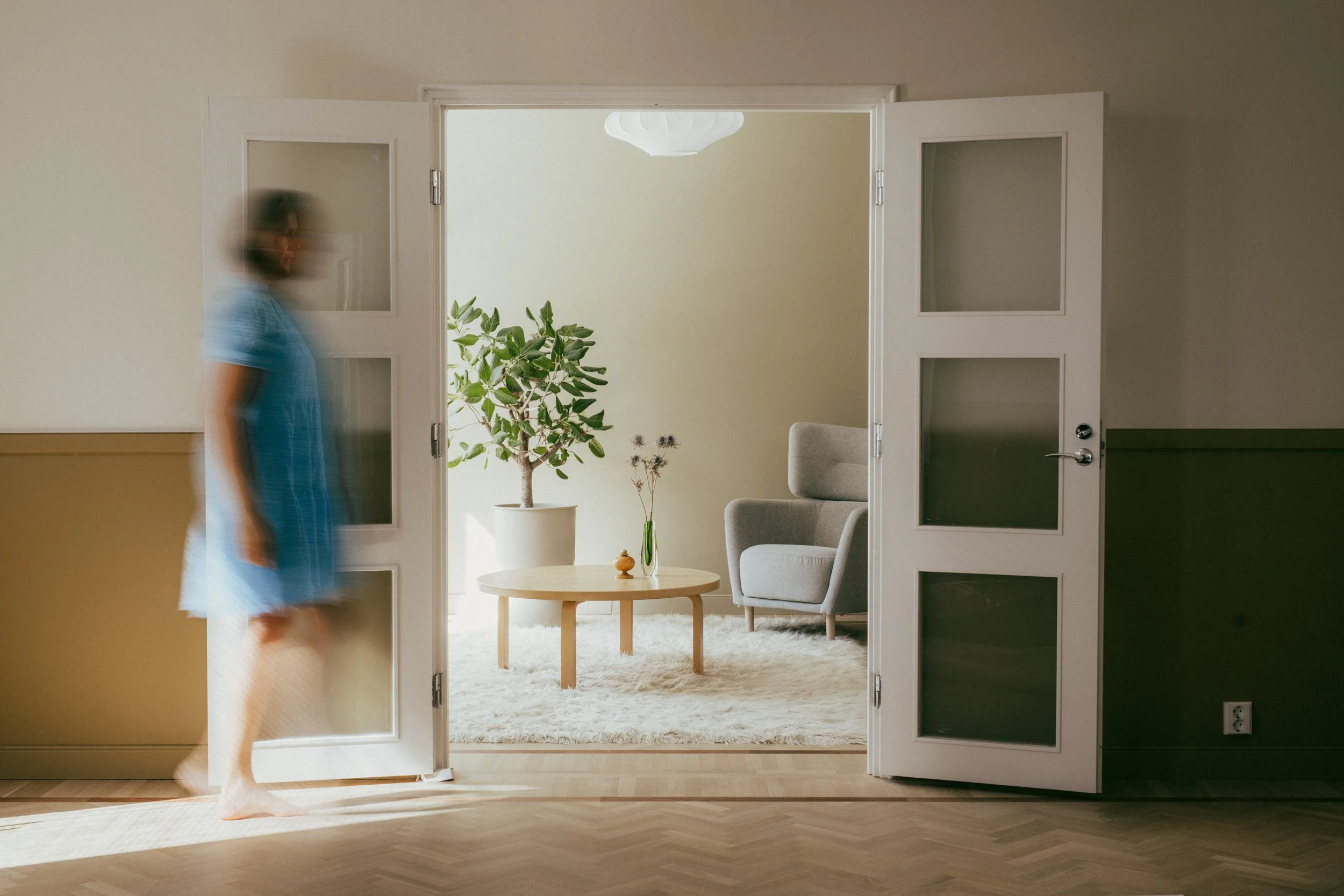 Renovated Helsinki interior with original doors, warm natural materials and a light-filled living room designed for everyday life.
