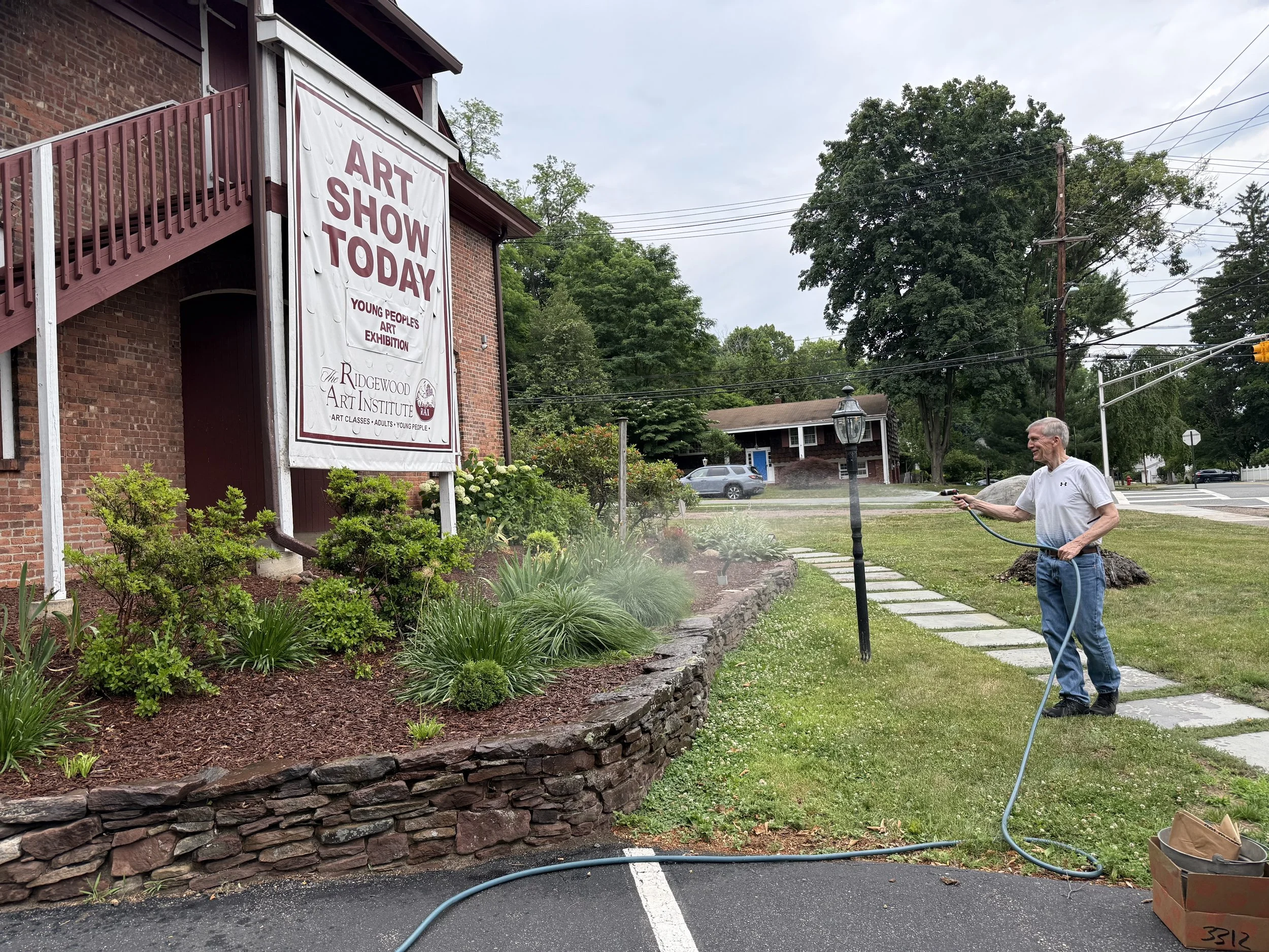 Treasurer Larry Bochet watering the garden.