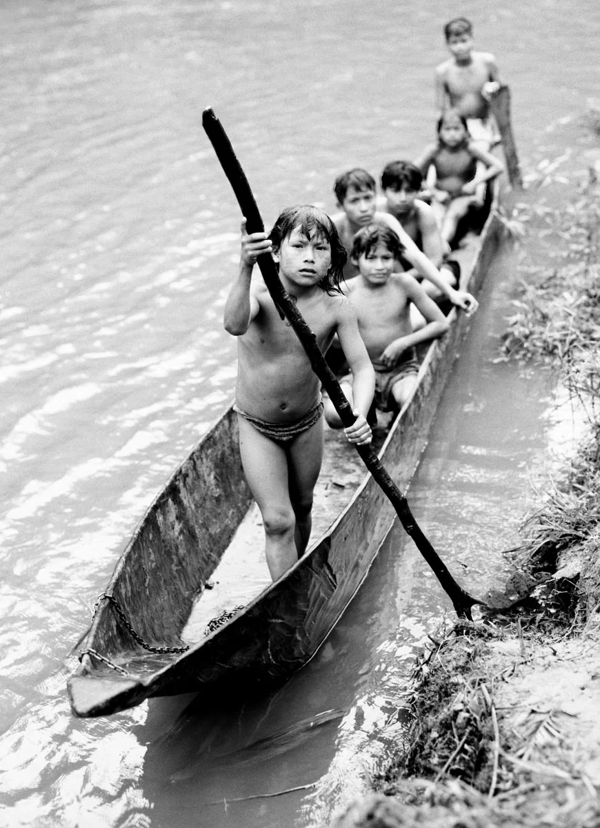 Kunang ( 8 ) using the dugout canoe to cross the river with his friends