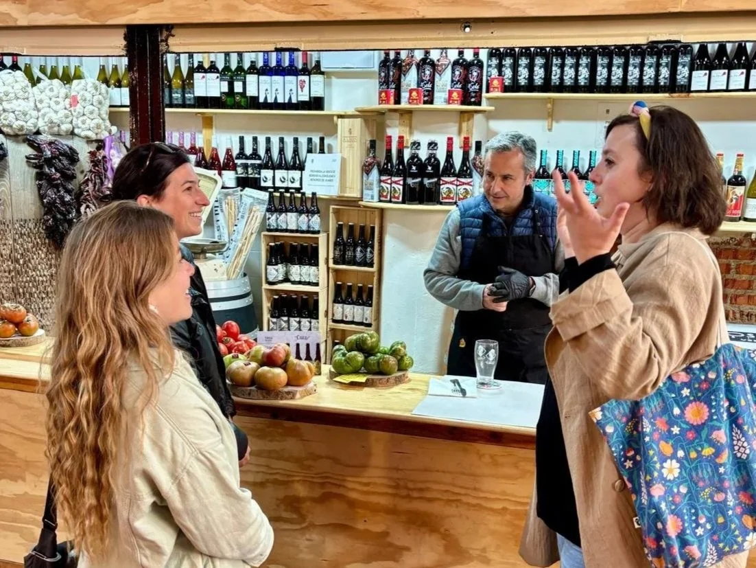 A guide introducers a fruit vendor during Walk and Eat's Historic Madrid Market and Tapas Tour in Madrid.