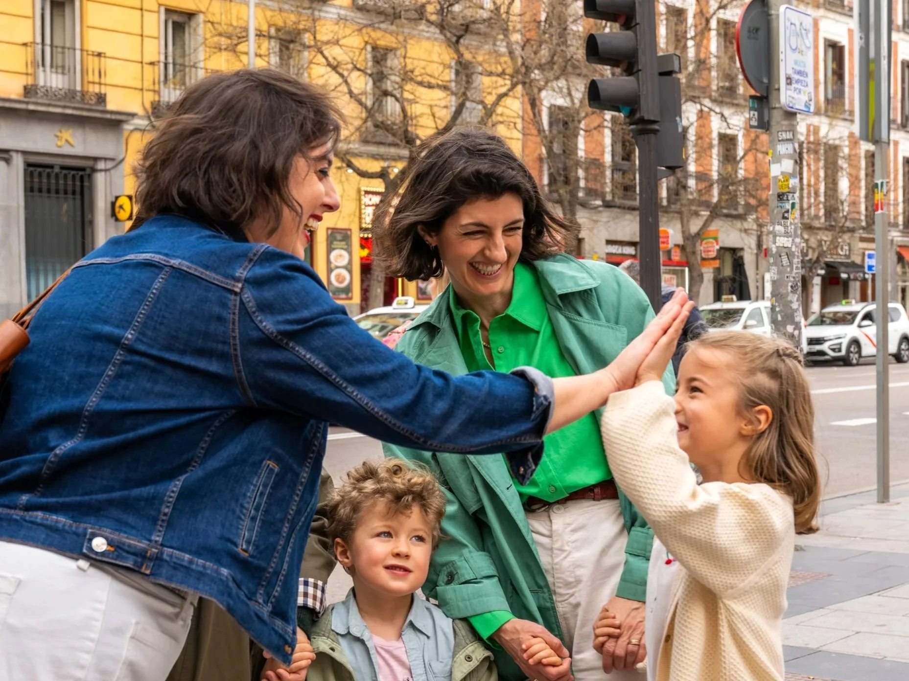 A family-friendly food tour guide gives a little girl a high five before starting a market tour in Madrid.