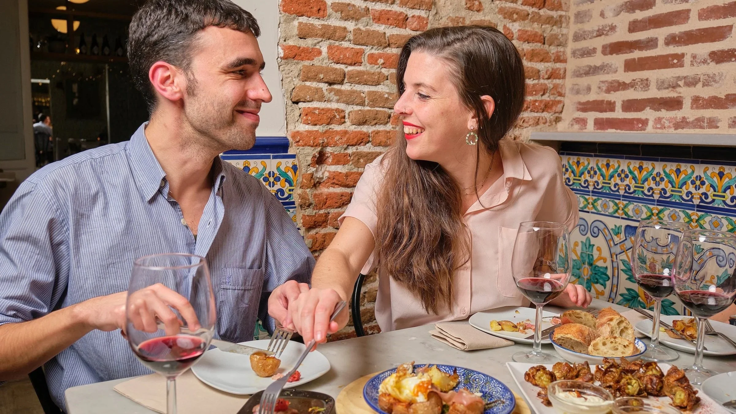 A couple enjoys tapas and wines on a private tapas tour in Madrid.