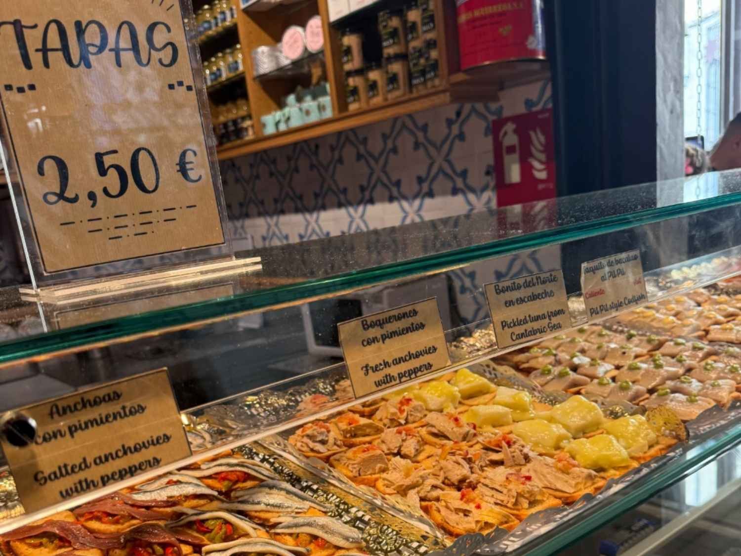 Bite-size toasts are topped with pickled fish inside the San Miguel Market in Madrid, a great lunch spot for families visiting Madrid.