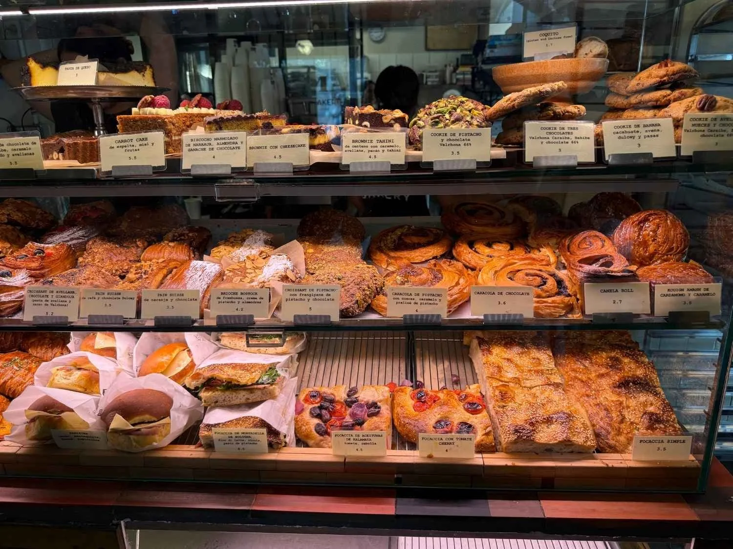 A display case is packed with freshly baked croissants, breads and other treats at Alma Nomad Bakery, on of the best breakfast spots in Madrid.