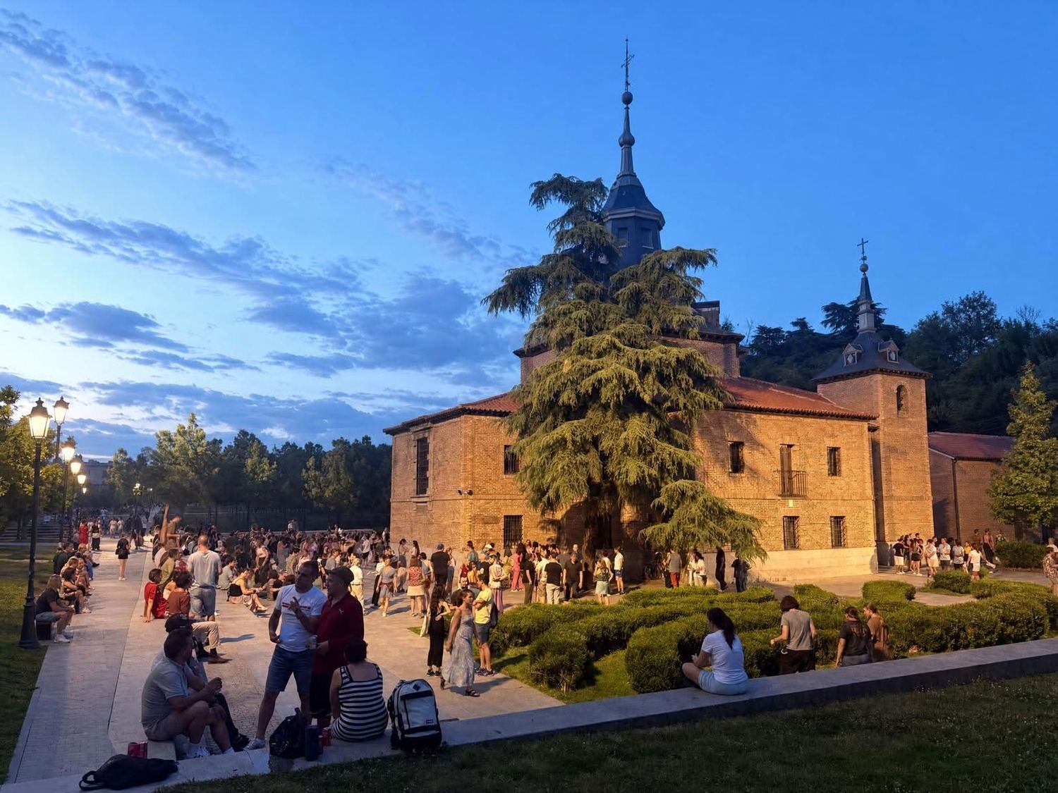 People dance salsa in front of a small church along the river in Madrid.