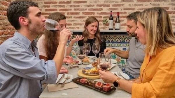 Four guests enjoy classic Madrid tapas and Spanish wines on the best tapas tour in Madrid.