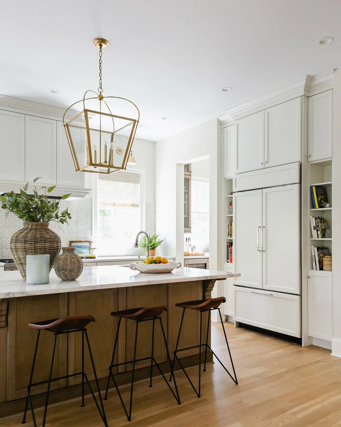 “Stepping into this kitchen is like a breath of fresh air! With crisp white cabinetry, built-in Wolf appliances, and elegant polished nickel faucets, this space strikes the perfect balance of style and function. The custom Tabarka tile backspla