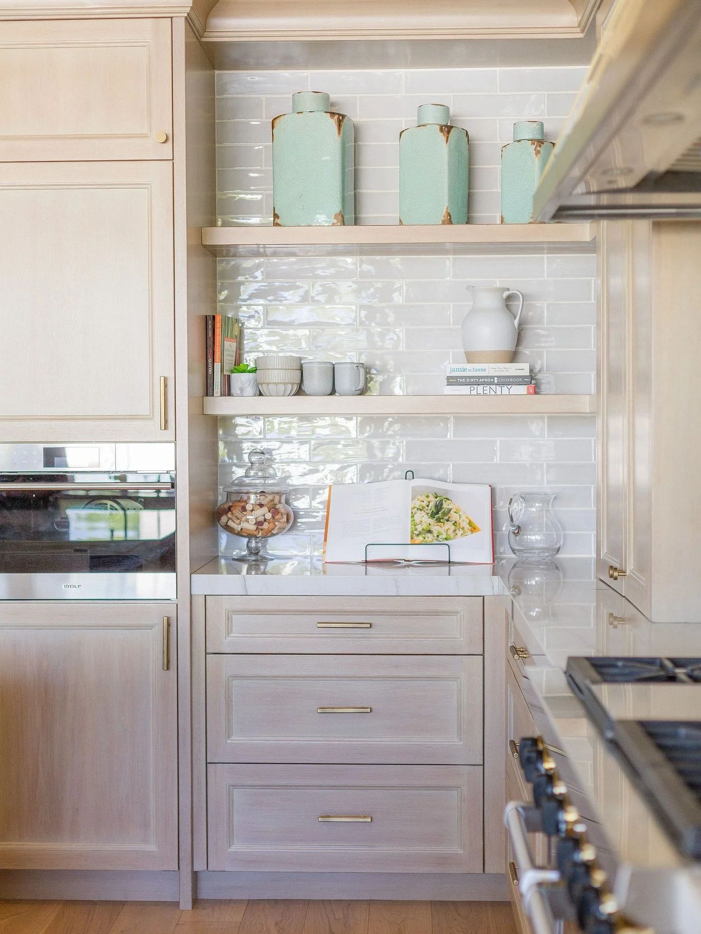 ✨ Kitchen moments that inspire ✨
A touch of timeless design&mdash;layered textures, warm wood cabinetry, brass hardware, and glossy backsplash tiles that catch the light just right. Styled with collected ceramics, everyday favorites, and a cookbook a