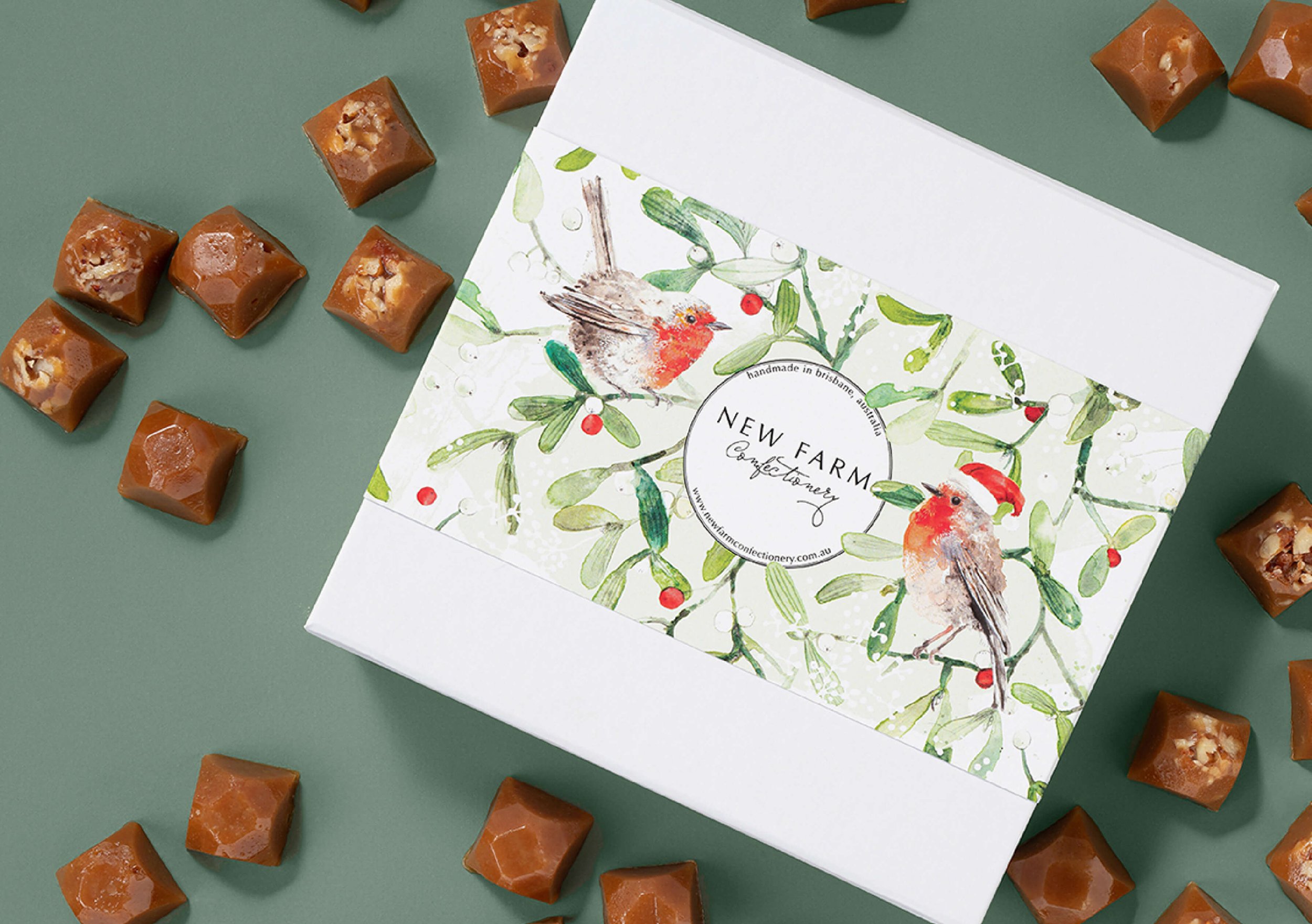 Hand-painted watercolour red robin and mistletoe packaging illustration created for New Farm Confectionery Christmas seasonal gift box campaign.