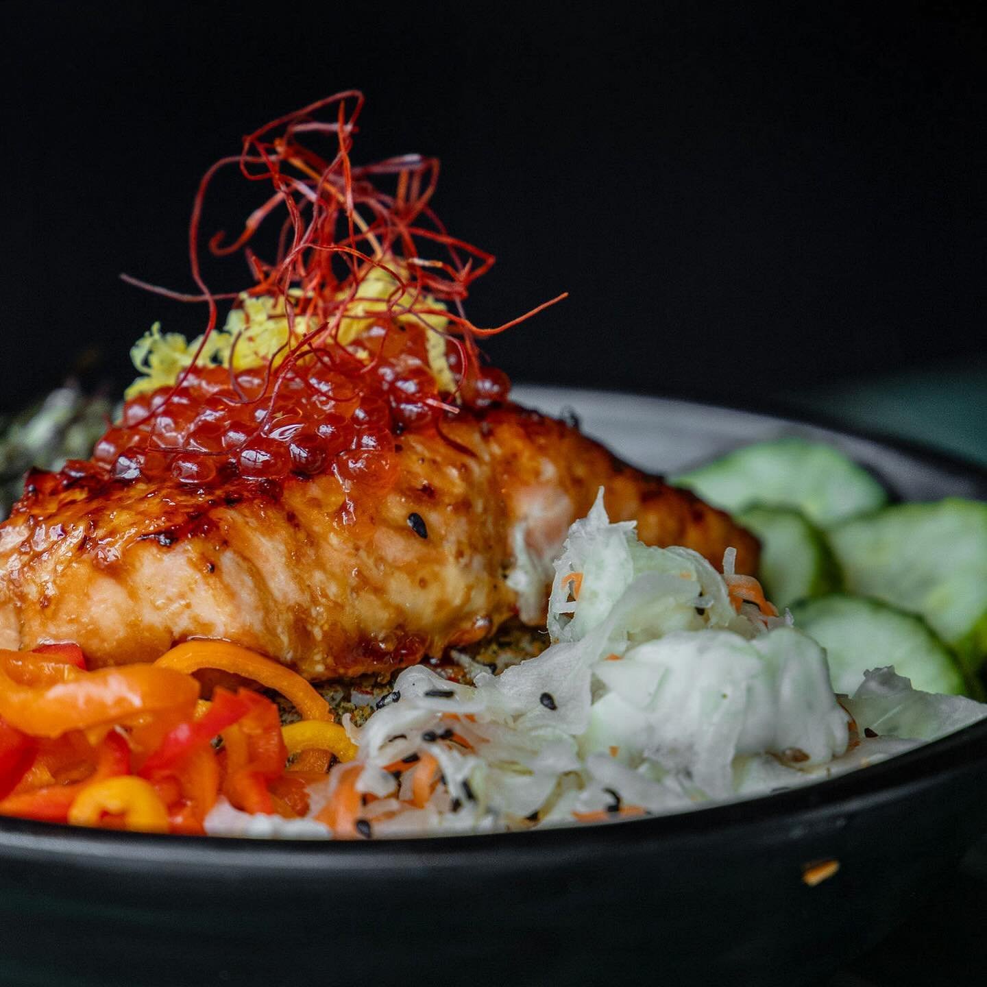 🥢Teriyaki salmon, topped with roe, accompanied by pickled veggies &amp; napa slaw on a bed of steamed sushi rice. 😍