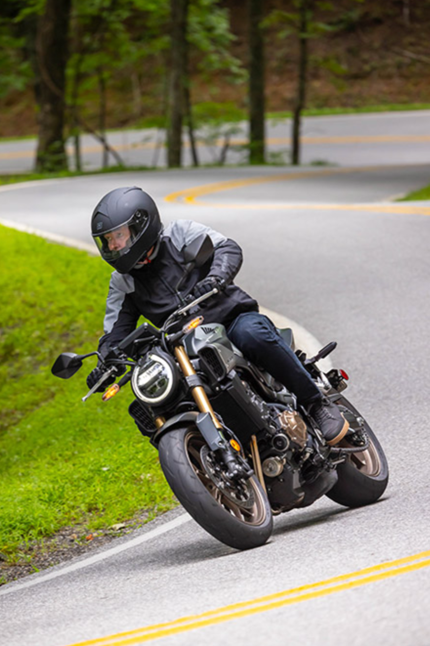 Man riding 2024 Honda CB650R on a twisty road.