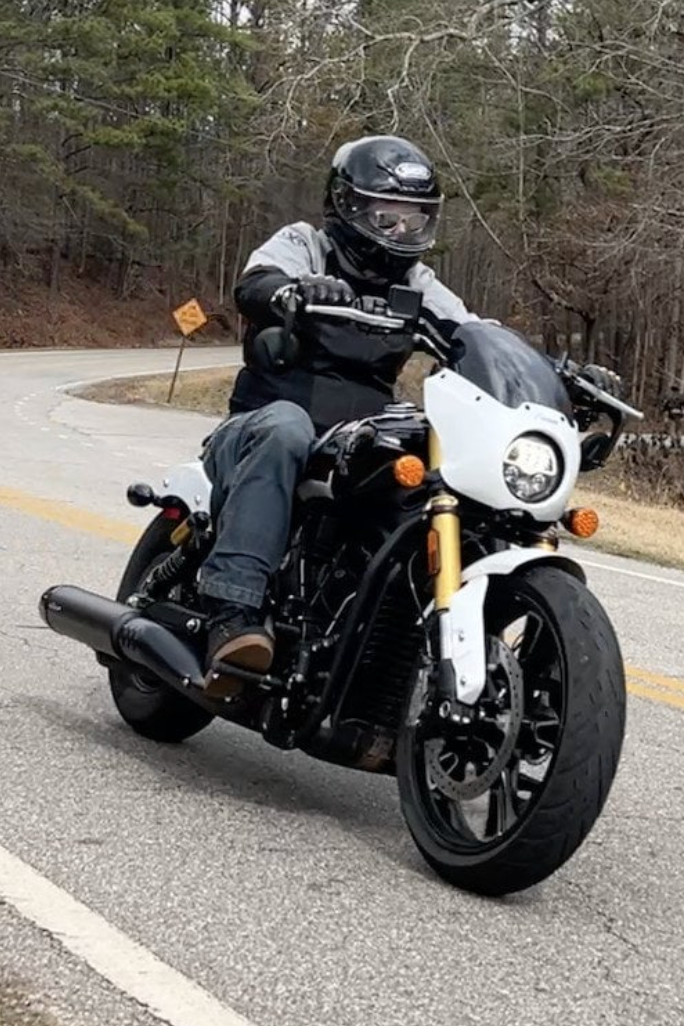 Man riding a 2025 Indian Scout 101 in a corner.