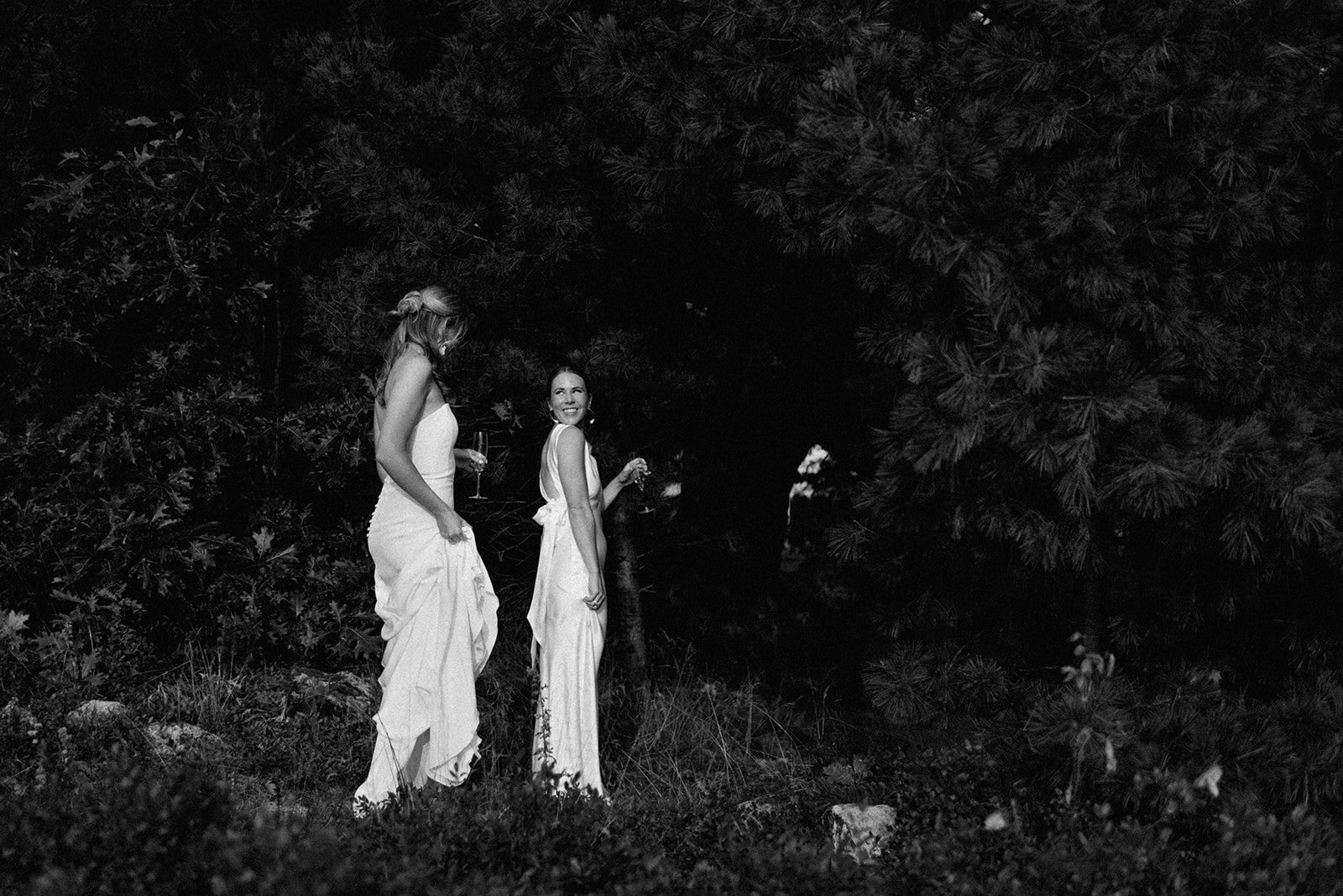 Family Home Kingston Wedding of Vanessa and Liz – playful moment as one bride sneaks a smile from behind a tree