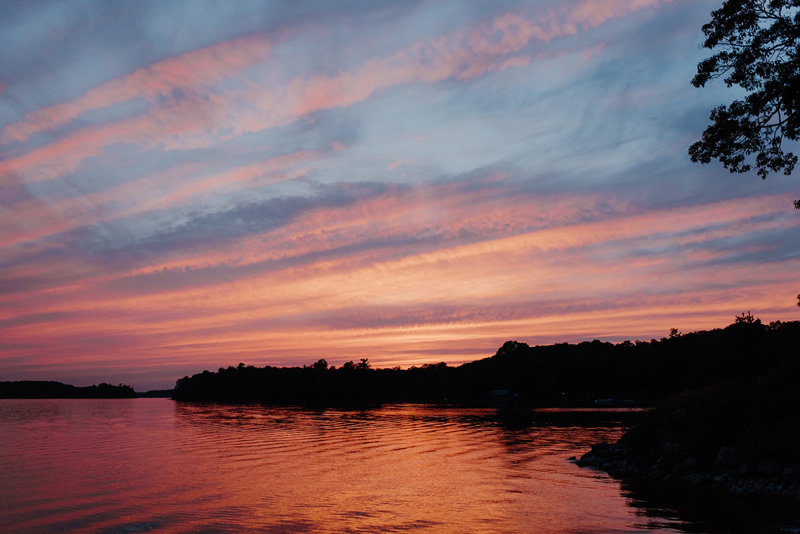 Family Home Kingston Wedding of Vanessa and Liz – stunning sunset over the lake at the wedding venue, casting warm golden light across the water