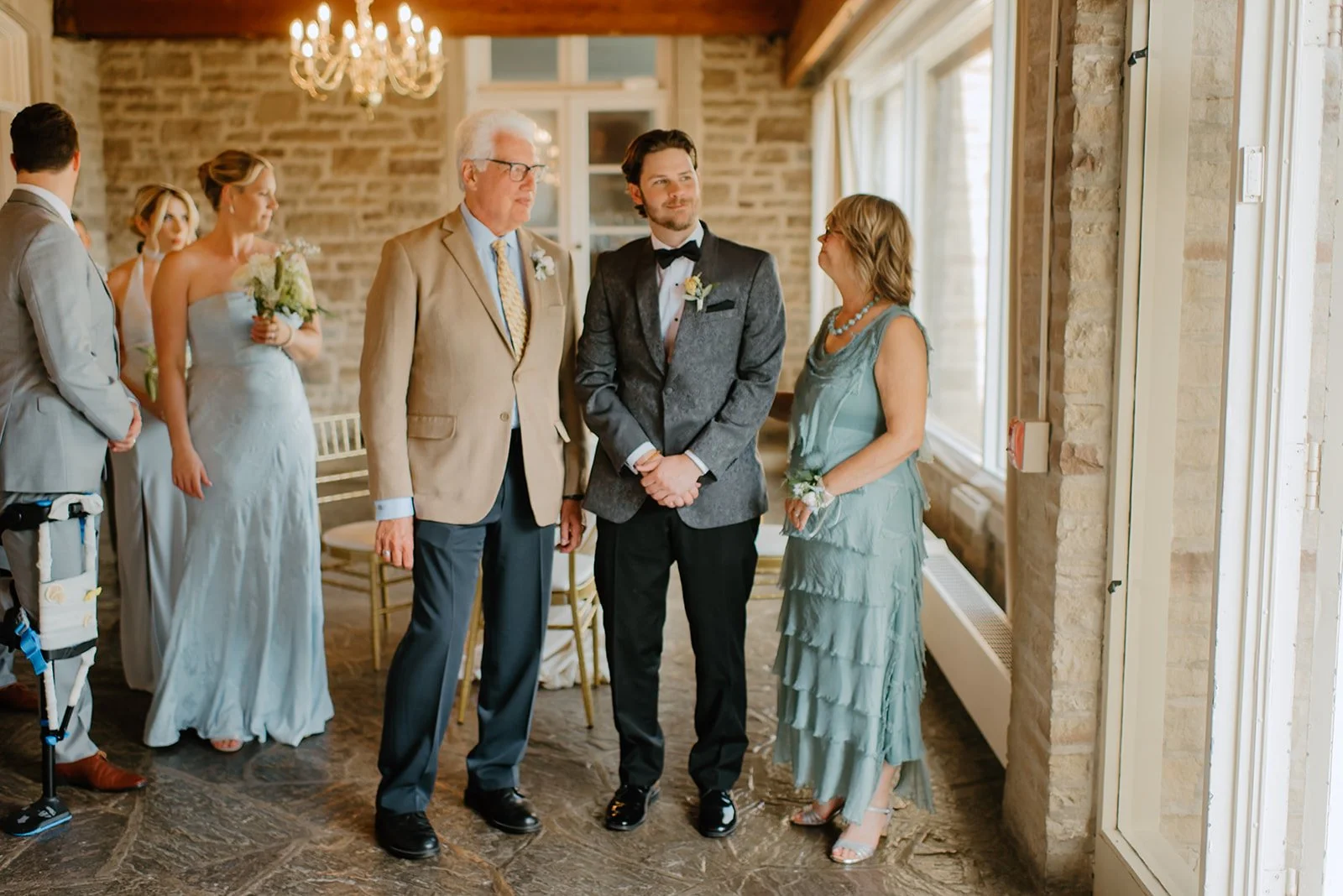 Eaton Hall Wedding in King City | Benita + Allen – The groom stands with family members inside Eaton Hall before the ceremony, surrounded by natural light and rustic elegance.