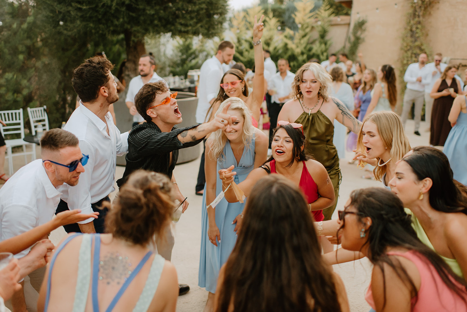 Castell de Barxell Wedding | A Romantic Spanish Countryside Celebration with Zuzanna + Raul – Guests mingling in the sun-drenched courtyard of Castell de Barxell.