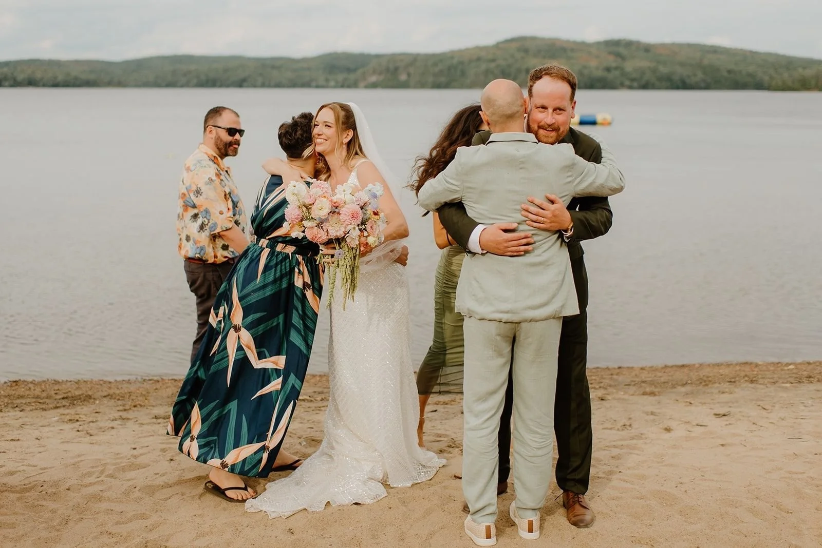 Camp Eden Woods Wedding in Ontario | Amy + Rory – Candid moments of Amy and Rory embracing family and friends during their rustic waterfront celebration.