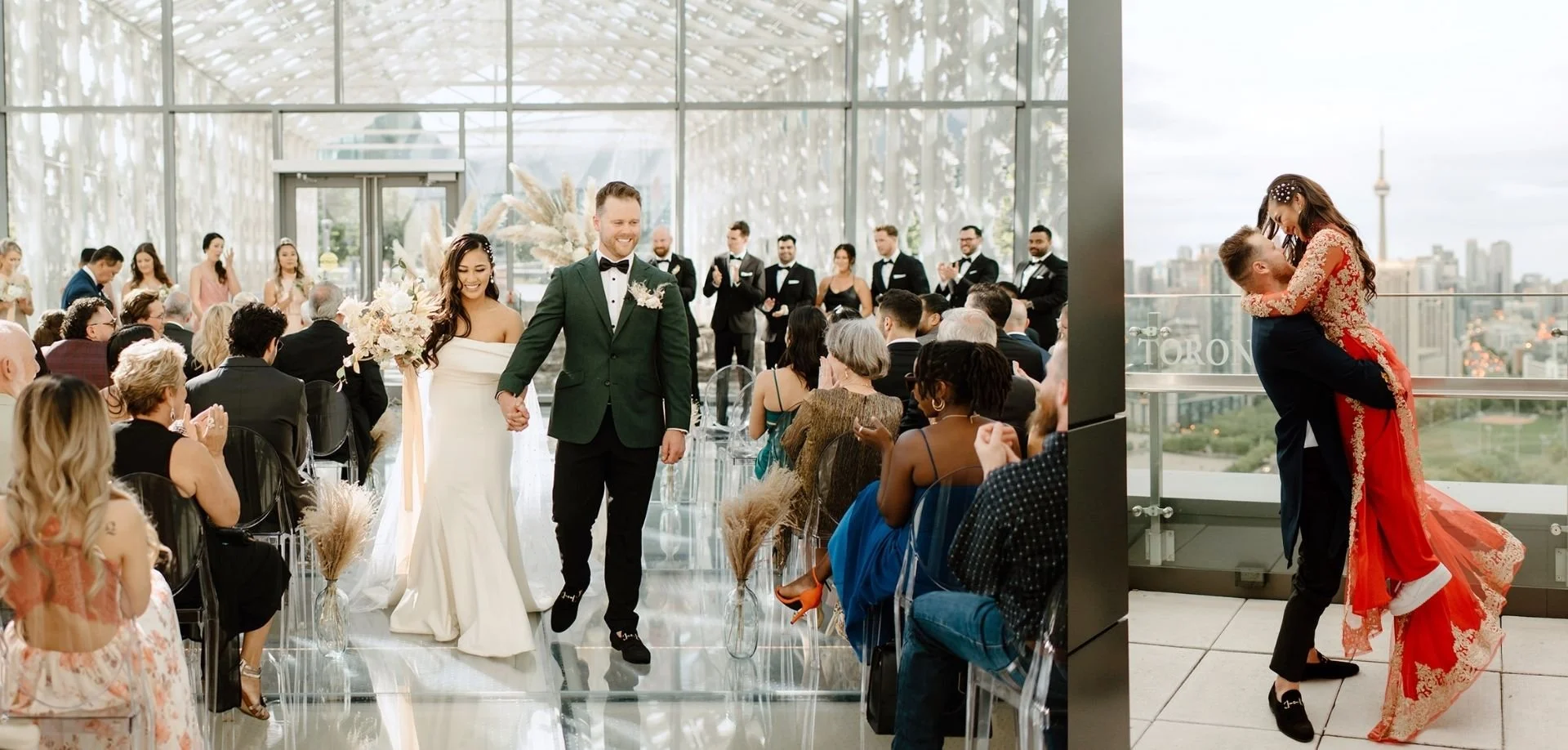 A bride and groom walk down a glass aisle and embrace on a rooftop at Hotel X Toronto.