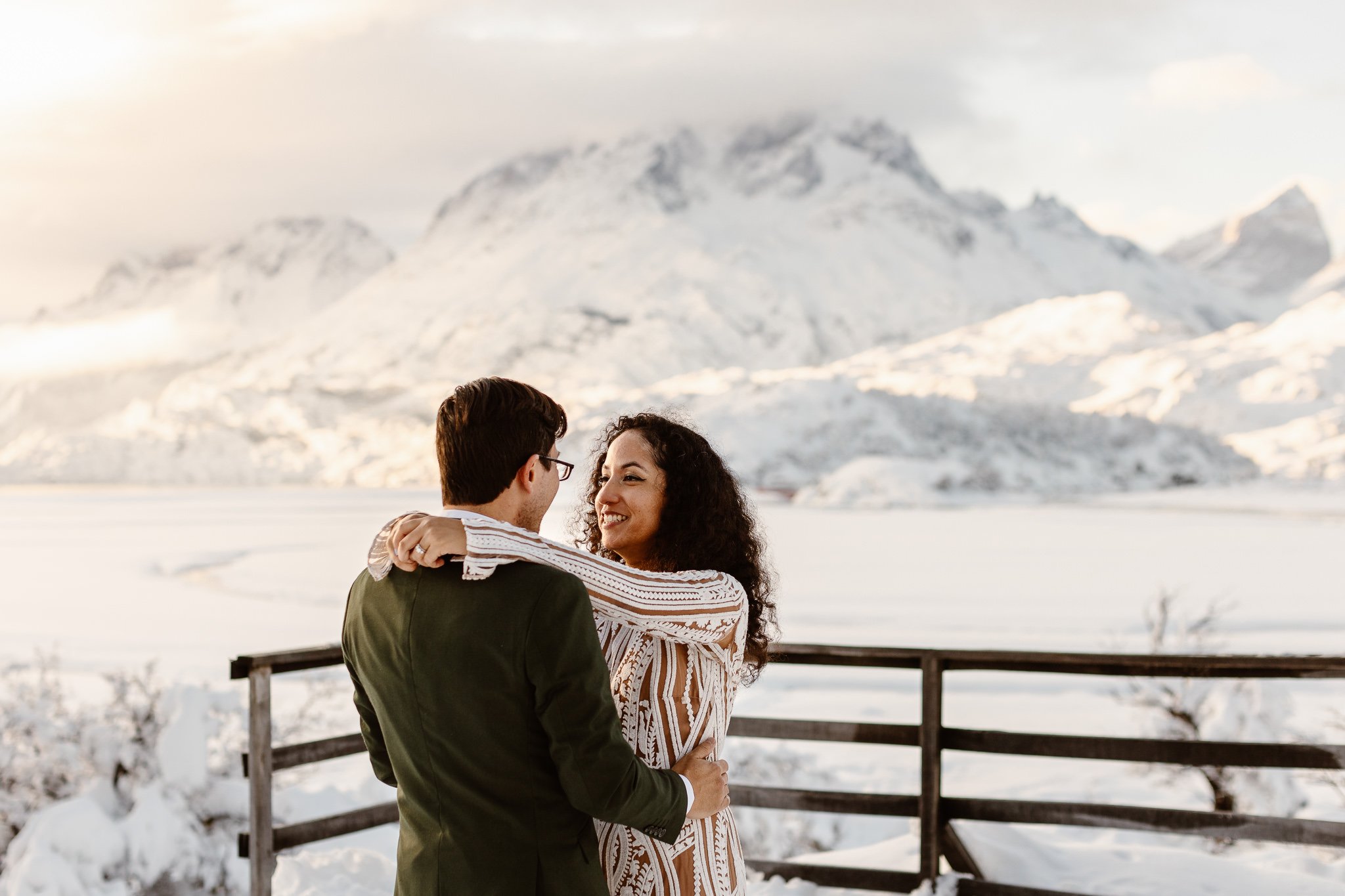 Newlyweds dancing and smiling during a snowy sunset at Torres del Paine