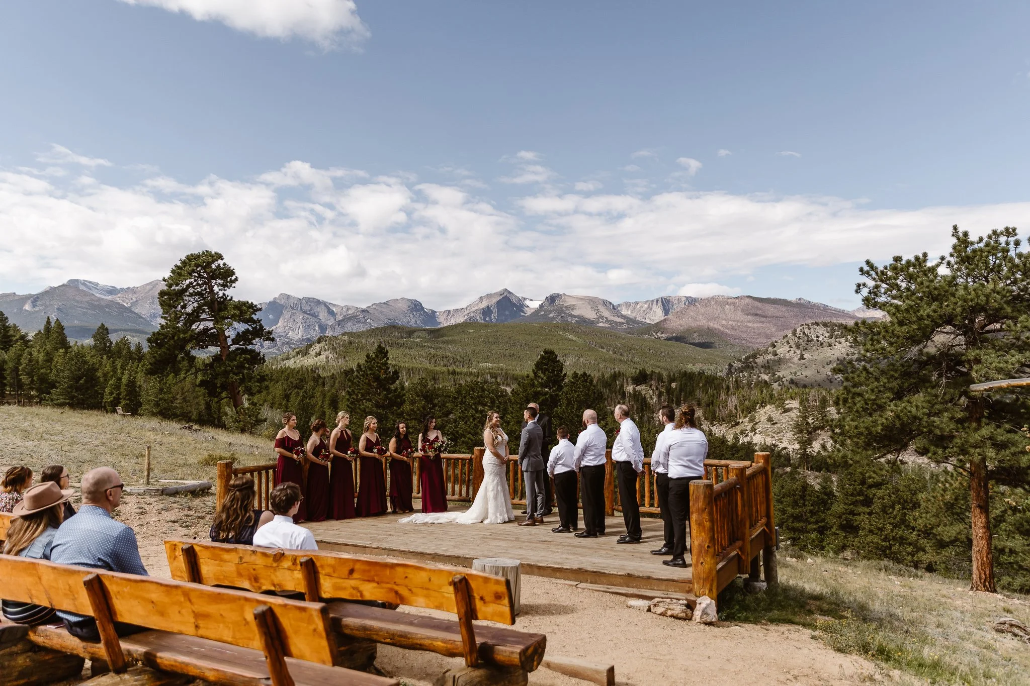 The wooden platform that holds a small wedding party during this outdoor ceremony amongst the mountains and trees at the YMCA of the Rockies.