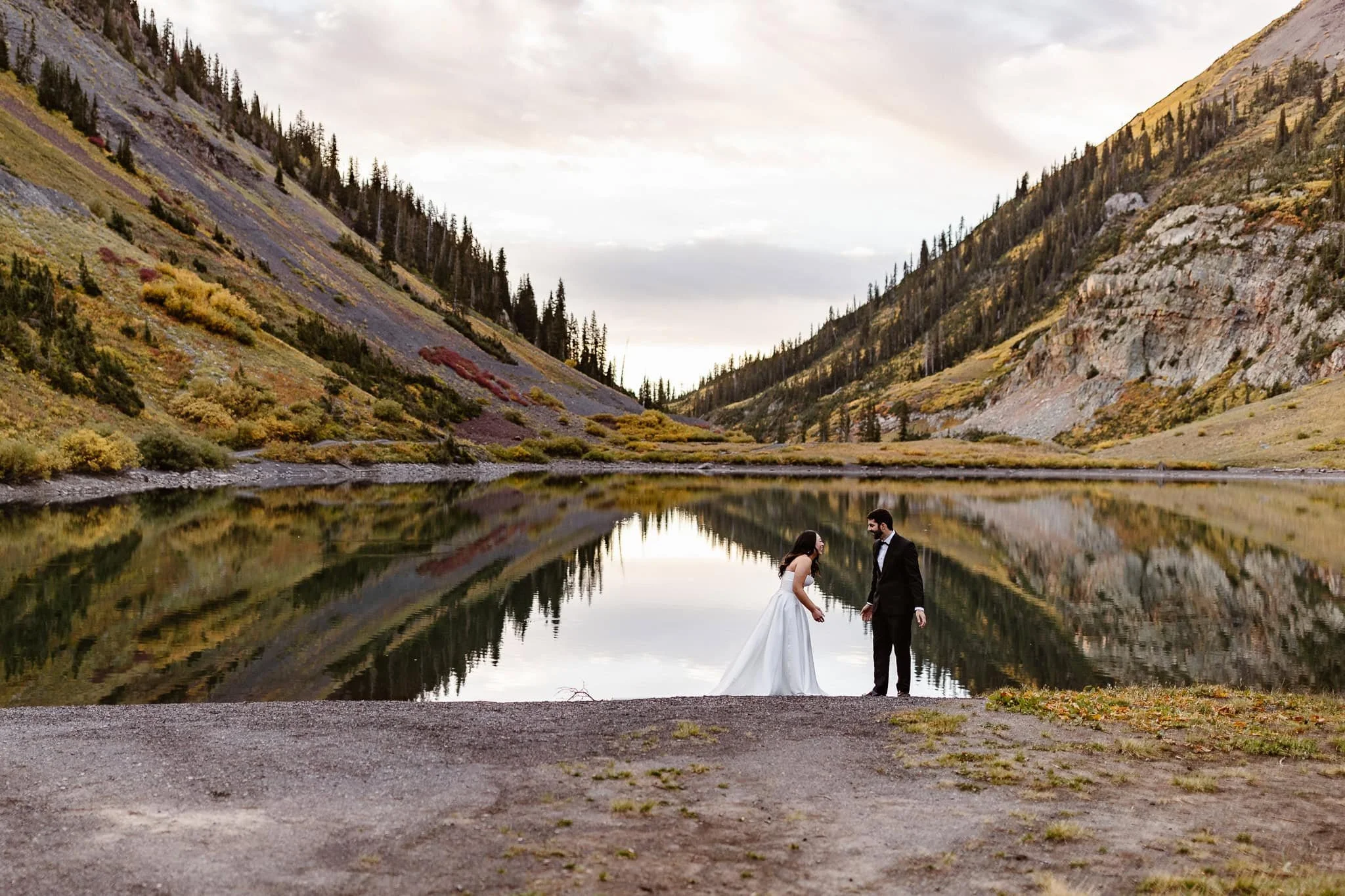 The groom's reaction to seeing his fiance in her wedding dress for the first time. The mountains behind them have pops of red, yellow, and green as the foliage turns for fall.