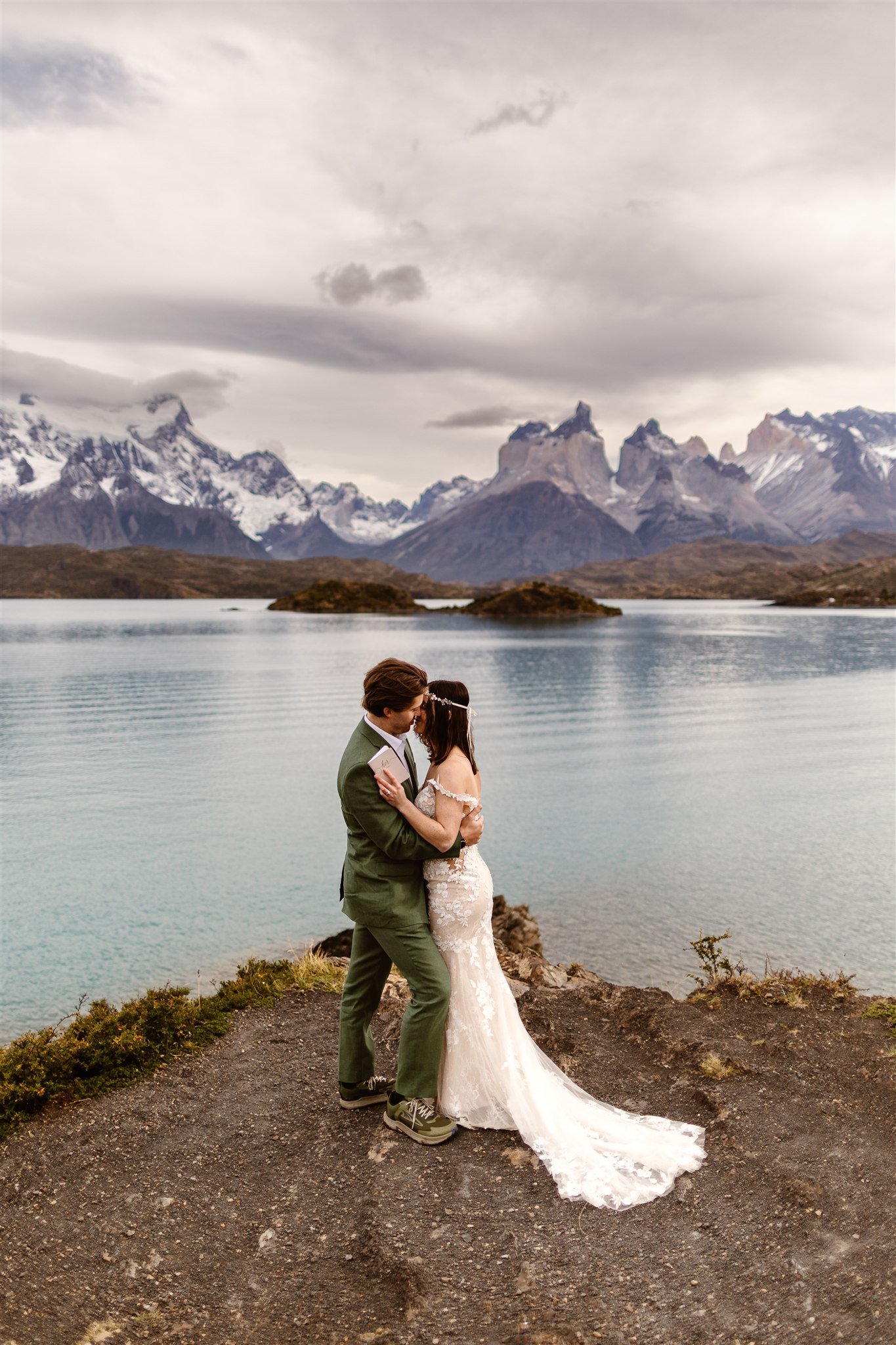 As they go in for their first kiss, the bride and groom hold each other closely, faces just barely touching as they smile deeply and savor this epic moment.